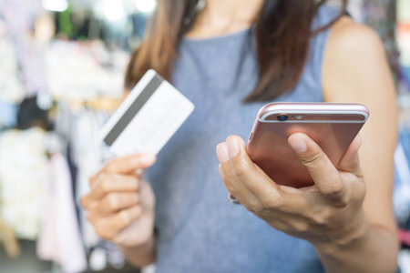 business man hands holding credit card and using phone and computer laptop. Online shopping purchase Sell or Paymentの素材 [FY310112477630]