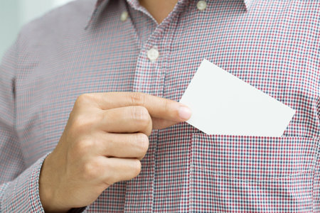 Young businessman who takes out blank business card from the pocket of his shirt business suit, copy spaceの写真素材