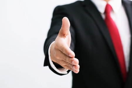 Business man in suit and red necktie open hand ready to seal a deal, hold out one's hand partner shake hands, copy space. white background.の写真素材