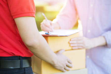people man signing receipt receiving package parcel delivery man of a package through a service. and close up hand customer accepting a delivery of boxes postal.の写真素材