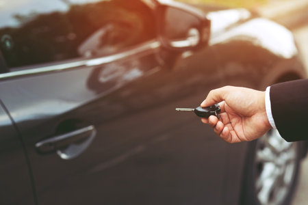 Cropped view of Closeup of a man's hand inserting key into the door lock of a carの写真素材