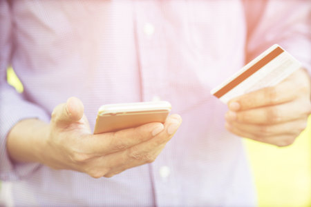 Hands holding credit card and using phone. Online shopping purchase Sell or Payment.の写真素材