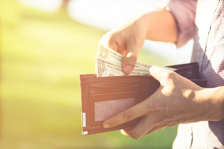 close up Businessman Person holding an wallet in the hands of an man take money out of pocket. finance conceptの写真素材