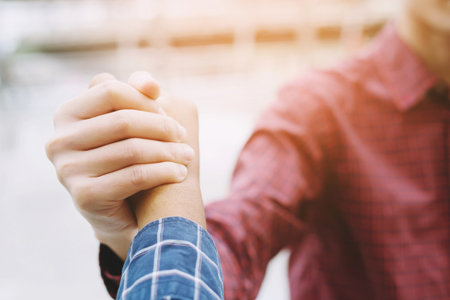 Closeup of a business man hand shake between two colleagues greet , Represents Friendship is good,success, congratulations. outdoor of building background. copy leave space for text.の写真素材