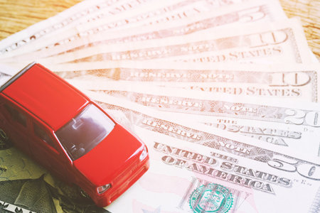 top view Little red car over a lot of money dollar euro bills, Cost calculation expenses for loans costs and payments installment concept.の写真素材
