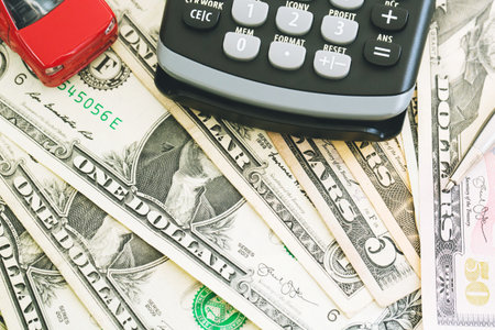 top view Little red car over a lot of money dollar euro bills,and calculator with pen. Cost calculation expenses for loans costs and payments installment concept.の写真素材