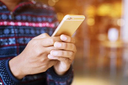 Young male using on cell phone during rest in office. sitting in watching message on mobile phone during break.の写真素材