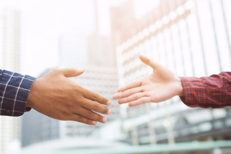 Closeup of a business man hand shake between two colleagues greet , Represents Friendship is good,success, congratulations. outdoor of building background. copy leave space for text.の写真素材