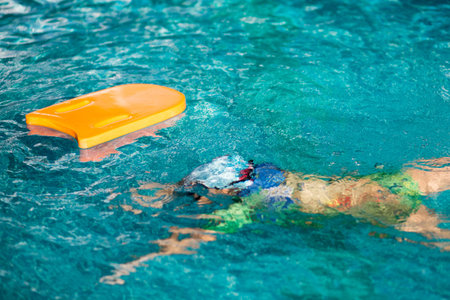 Small children swimming floating upside down in blue clear water swimming pool, to demonstrate child drowning in swimming pool.の写真素材