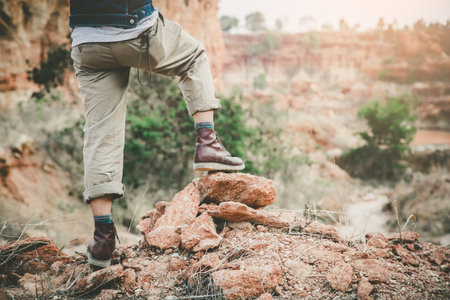young hiker legs on mountain peak cliffの写真素材