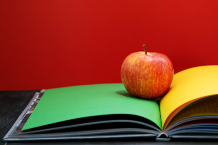 Red apple placed on the book. background redの写真素材