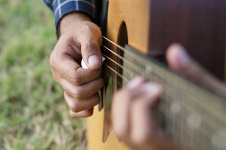 Acoustic guitar guitarist playing. Musical instrument with performer hands in parks.の写真素材