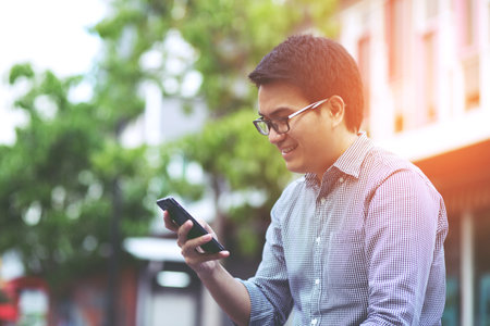 people casual wear using on cell phone during on sofa. sitting in watching message on mobile phone Symptoms sad unhappy young man holding his forehead while having headache receive a bad news messageの写真素材