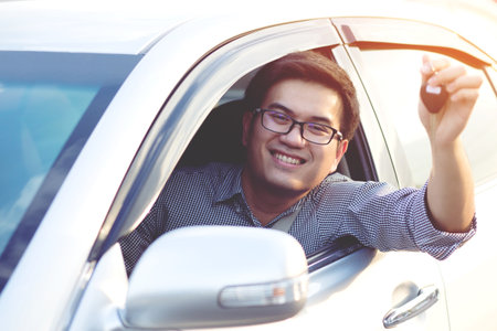 Young men thumbs Good mood while driving Ready to leave.の写真素材
