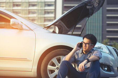 Angry man Stand front a broken car calling for assistanceの写真素材