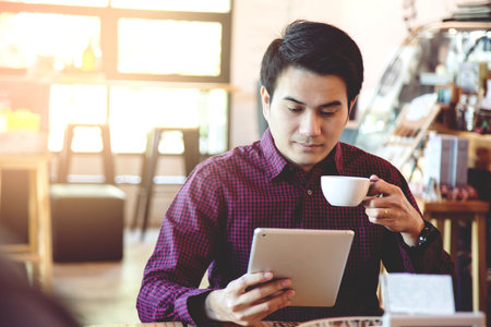 Handsome Business man in an using telephone in coffee shop.の写真素材