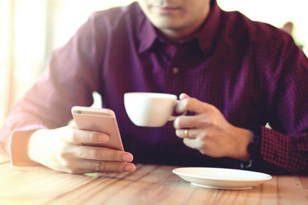 Handsome Business man in an using telephone in coffee shop.の写真素材