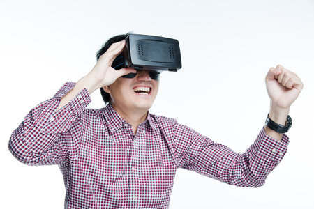 Man wearing virtual reality goggles excited impassioned mood. Studio shot, white background.の写真素材
