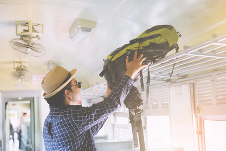 Young man traveler with backpack Luggage storage Departure go to train. Travel concept.の写真素材