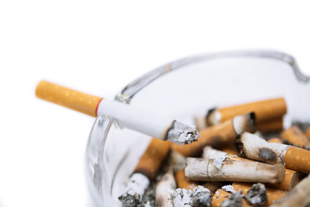 smoking a cigarette on ashtray in white background.の写真素材
