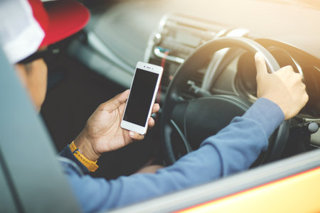 Young man put on a driving car and using smart phone mobile phone.の写真素材
