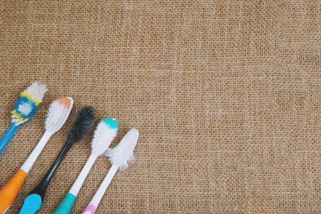 Toothbrush old used expired Colorful variety, top view on sackcloth background.の写真素材