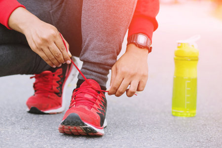 Running shoes. Barefoot running shoes closeup. male athlete tying laces for jogging on road. Runner...
