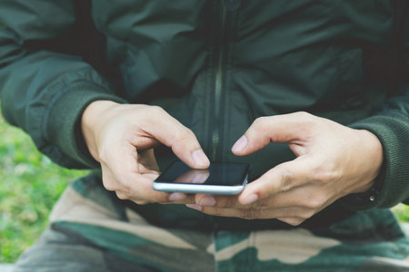 close up of Man Soldier plainclothes using mobile smart phone.の写真素材