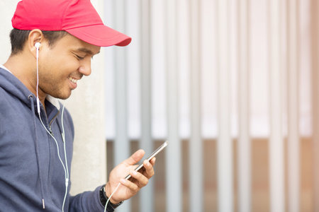 Asian man jogger listening music in headphones after training In good weatherの写真素材