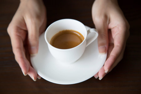 Hands of man holding entwine cup of coffee heart-shaped.の写真素材