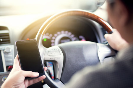 Young man put on a driving car and using smart phone mobile phone.の写真素材