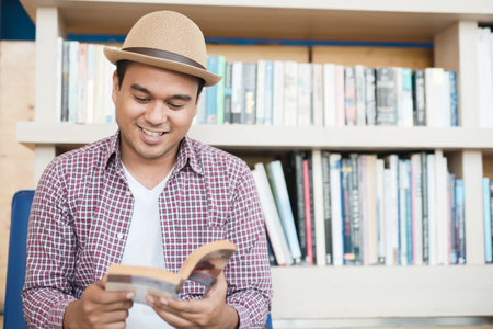 The man is reading a book in the library.の写真素材