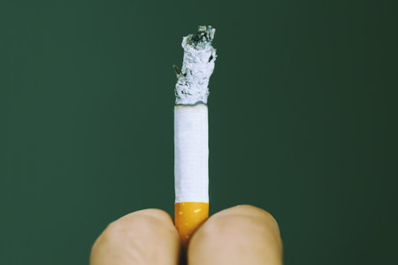 The man smoking a cigarette in hand. Cigarette smoke spread.