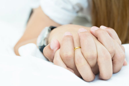 Hands of couple lovers on a bed at honeymoon with lust and love. Concept about love, sex and lifestyle.の写真素材