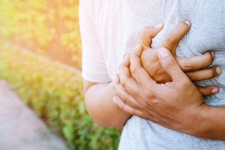 Man having chest pain - heart attack outdoors. or Heavy exercise causes the body to shocks heart diseaseの写真素材
