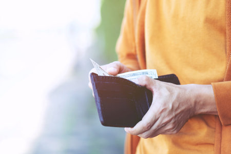 close up young man Person holding a wallet in the hands of an man take money out of pocket. finance conceptの写真素材