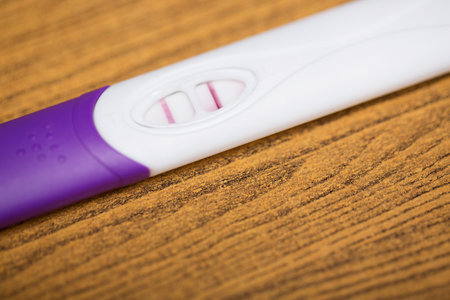 Positive White Plastic Pregnancy Test Display results for pregnancy. on wooden Background.の写真素材