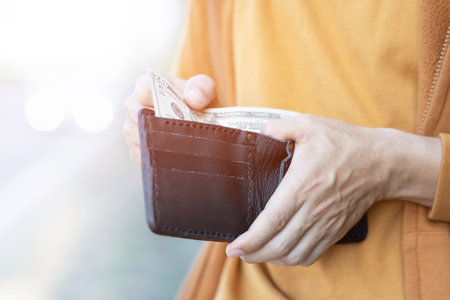 close up Businessman Person holding an wallet in the hands of an man take money out of pocket....