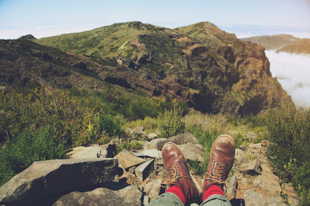 Traveler resting man hipster hiking boots having fun and enjoying wonderful breathtaking the forest mountain rocks view. Freedom concept. hiking shoes and man legs.の写真素材