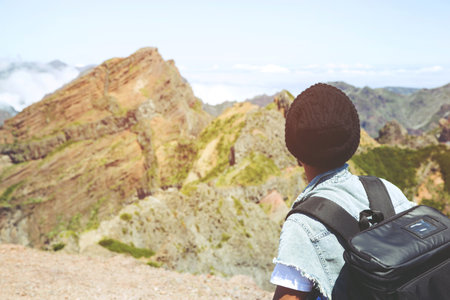 young man hiking traveling standing on top of cliff in summer travel Lifestyle wanderlust adventure with backpack enjoying on peak mountain. Tourist traveler on background valley landscape view.の写真素材