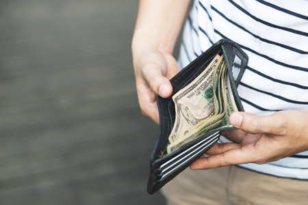 close up Businessman Person holding an wallet in the hands of an man take money out of pocket.の写真素材