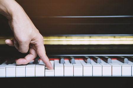 close up of hand people man musician playing piano keyboard with selective focus keys. can be used as a background.の写真素材