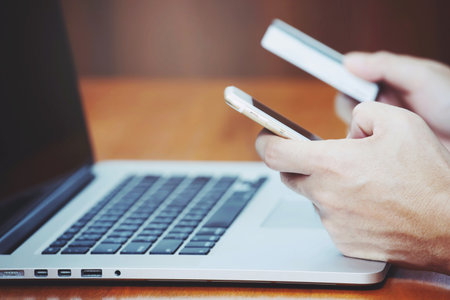 close up people hands holding credit card and using phone and computer laptop. Online shopping purchase Sell or Payment.の写真素材