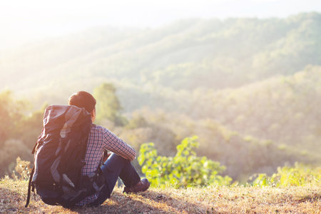 Traveling tourist hipster man Backpack looking at amazing tropical high mountains forest scenic views. Travel Camping Hiking Journey holiday Freedom concept Concept. atmospheric moment summer vacationの写真素材