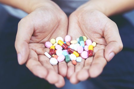 close up hand man taking multiple colors pills in hand. Stop drug use Taking Medication health care medical conceptの写真素材