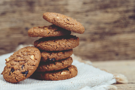 Close up of a group Chocolate chip cookies many stacked on dark old rustic wooden plank table with Leave Copy space place for text. freshly baked. Selective Focus.の写真素材
