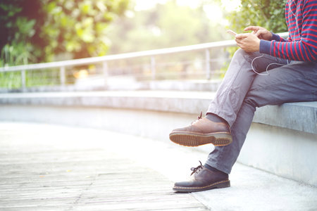 Back view of a close up of Young Man using mobile smart phone.の写真素材