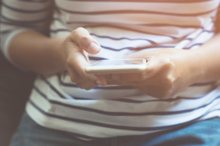 people casual wear using on cell phone during on sofa. sitting in watching message on mobile phone Symptoms sad unhappy young man holding his forehead while having headache receive a bad news messageの写真素材