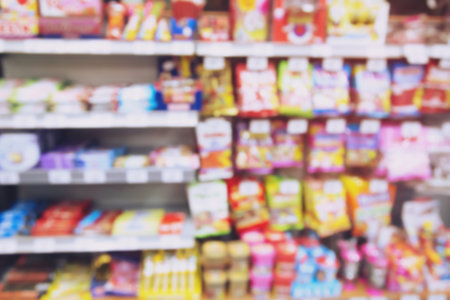 Abstract blur supermarket discount store and candy taffy snack product brands Colorful variety  shelves interior retail store in shopping mall backgroundの写真素材