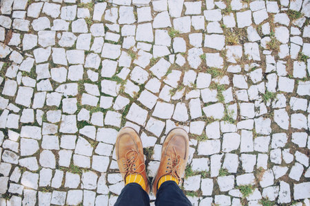 close up legs and shoes Young man hipster stand walking brick mosaic on the concrete road floor grass of city, Aerial top view. Leave empty space blank to Write a message. travel journey concept.の写真素材